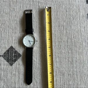 Of All Threads watch. Black leather band, white face, blue hands.